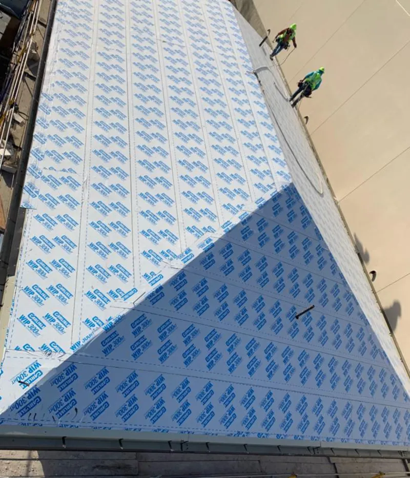 Professional roofers installing underlayment on a metal roof in New Fairfield